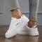 White sports shoes with gold details for women