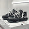 Chaussures de sport noires et blanches avec lacets épais